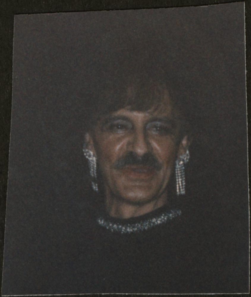Person in moustache, earings, wig, and makeup