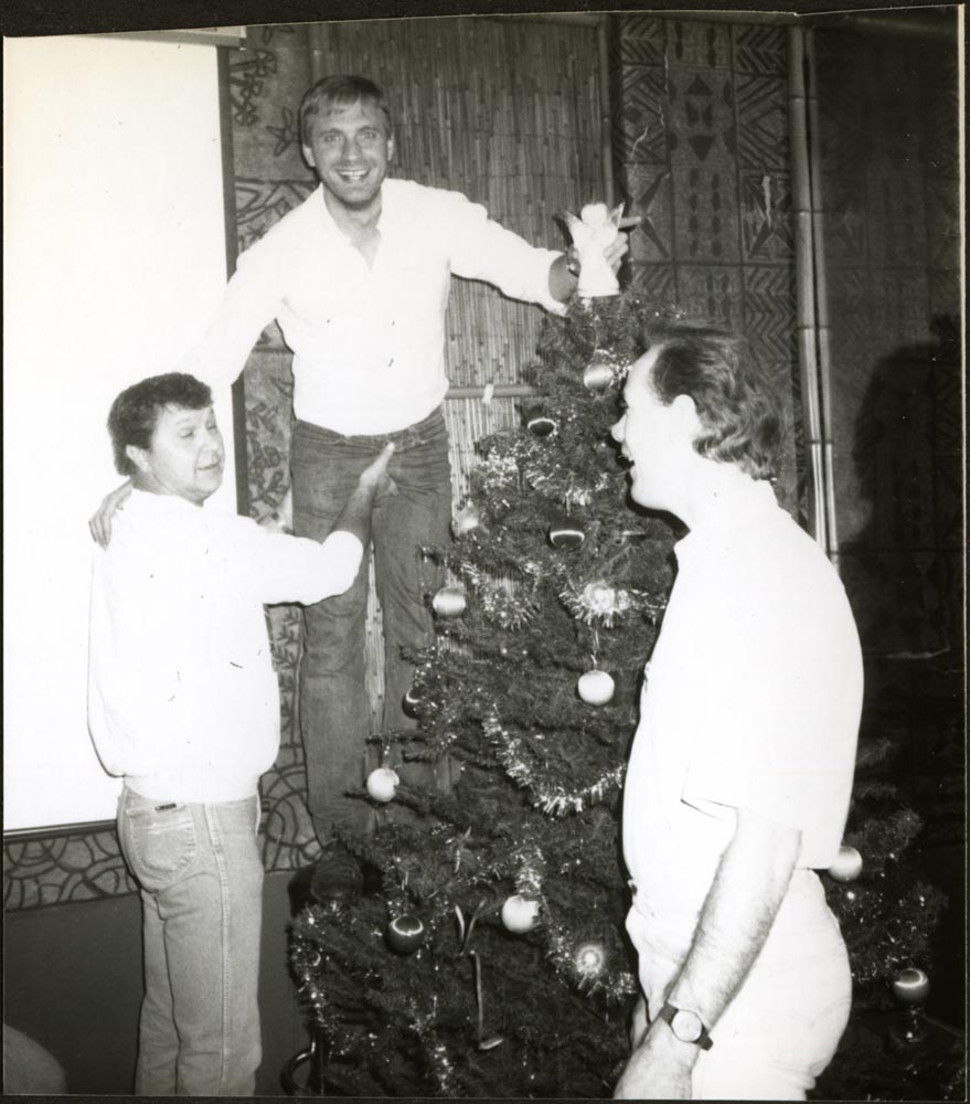 Buddy Tayolr decorating a Christmas Tree with two friends