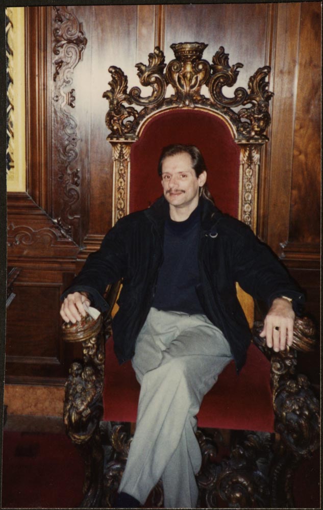 Person with moustache sitting at a throne